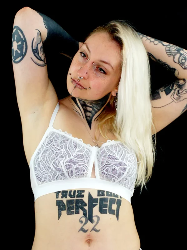 Eva porte un soutien-gorge corbeille en dentelle salma blanche, avec des coques violettes