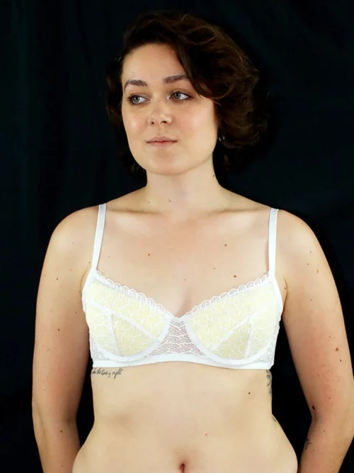 Lisa porte un soutien-gorge emboitant en dentelle blake blanche, avec des coques jaunes